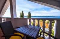 a table and chairs on a balcony with a view of the ocean at Apartman Joso in Diklo
