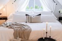 a white bed with two candles on top of it at Fully Equipped Home Close to Malmö &amp; Copenhagen in Vellinge