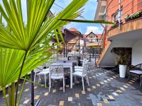 een patio met witte tafels, stoelen en planten bij La Bujor in Breb