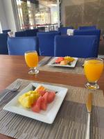 Hotel Down Town Cabrera في كابريرا: طبقين من الفاكهة على الطاولة مع كوبين من عصير البرتقال