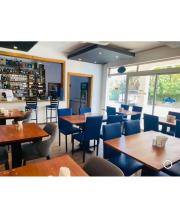 Hotel Down Town Cabrera في كابريرا: مطعم بطاولات خشبية وكراسي زرقاء