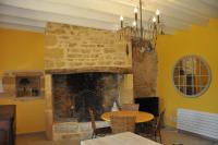 a stone fireplace in a dining room with a table at Gîte chez le Gaulois in Carsac-Aillac
