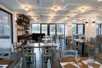 a restaurant with wooden tables and chairs and windows at Montelleri Residenza di Campagna in Vicchio