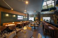 a restaurant with tables and chairs and a bar at Bilderberg Parkhotel Rotterdam in Rotterdam