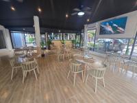 um restaurante com mesas e cadeiras e uma tela grande em H&Y Chaweng em Koh Samui 