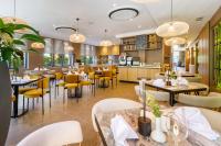 a restaurant with tables and chairs and a kitchen at Regnum Banya Thermal Hotel in Banya