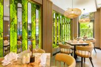 a restaurant with tables and chairs and green walls at Regnum Banya Thermal Hotel in Banya