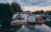 un grupo de edificios al lado de un cuerpo de agua en The Mitre, Hampton Court, en Kingston upon Thames