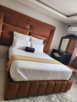 Un dormitorio con una cama grande con cabecero de madera. en Duplessis Lodge, en Kempton Park