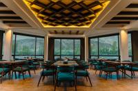 Un comedor con mesas y sillas y ventanas. en Cascade Resorts Ghawari, Gilgit-Baltistan, en Kuru