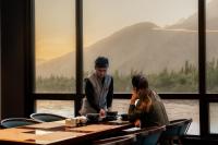 Un hombre y una mujer sentados en una mesa en un restaurante. en Cascade Resorts Ghawari, Gilgit-Baltistan, en Kuru