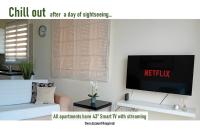 Una sala de estar con televisión y un sofá. en Kato Paphos Suites, en Nea Paphos