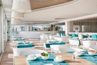 a dining room with blue tables and white chairs at The Sea Hotel by Grupotel - Adults Only in Can Picafort