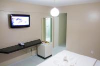 a room with a bed and a tv on the wall at JR Hotel in João Pessoa