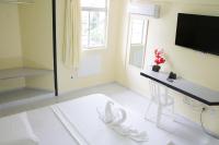 a room with a desk and a television on a wall at JR Hotel in João Pessoa