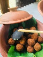 a bowl filled with meatballs on a green leaf at Cinnamon Leaf Leisure Resort in Badureliya
