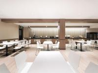 a dining room with tables and white chairs at Hanting Hotel Beijing Qianmen Street in Beijing