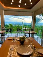 uma sala de jantar com uma mesa e uma grande janela em Castle View Hotel Samal em Magamomo