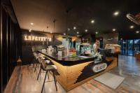 een restaurant met een toonbank met krukken in een kamer bij Oasis in CityGate 1BR Suite in Kamala Beach