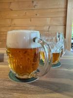 due bicchieri di birra seduti su un tavolo di legno di Penzion Eisenberg a Tvrdkov