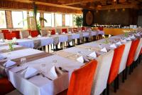 a row of tables in a restaurant with white table settings at Urban Park Suites Hotel in Kigali