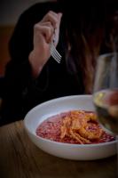 una mujer sentada en una mesa con un tazón de comida en Casa Serras Andorra, en Andorra la Vella