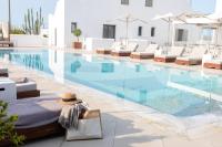 Una piscina con tumbonas y un sombrero al lado. en 18 Grapes Hotel, en Agios Prokopios