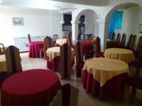 Un comedor con mesas y sillas con mesas moradas y amarillas. en Lincoln Prestige Hotel, en Accra