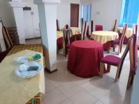 Un comedor con mesas y sillas y una mesa roja. en Lincoln Prestige Hotel, en Accra