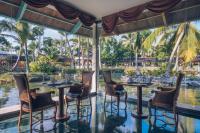 Un restaurante con mesas y sillas y vista al agua. en Iberostar Selection Bavaro Suites - All Inclusive, en Punta Cana