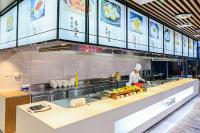 a chef preparing food in a restaurant kitchen at 北京明珠酒店Beijing CSN Pearl Hotel in Beijing