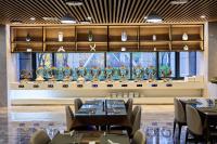 a dining room with tables and chairs and a large window at 北京明珠酒店Beijing CSN Pearl Hotel in Beijing