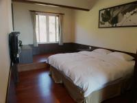 a bedroom with a large white bed and a window at Tea Cloud B&amp;B in Leye