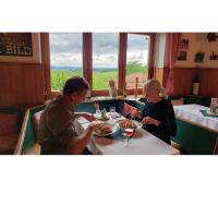 Un hombre y una mujer comiendo en una mesa en un restaurante. en Landrasthaus Maria Bild, en Maria Bild