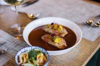 - une table avec un bol de nourriture et un verre de vin dans l'établissement Menlyn Boutique Hotel, à Pretoria