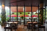 un restaurante con mesas, sillas y sombrillas rojas en Five Hotel & Residences, en Asunción