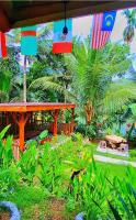 Un jardín con palmeras y una casa con banderas. en Bamboo Craft Homestay, en Sangyang