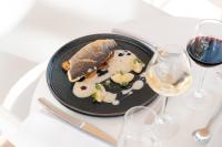 un plato de comida en una mesa con copas de vino en Westotel Le Pouliguen, en Le Pouliguen