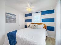 ein Schlafzimmer mit einer blau-weißen gestreiften Wand in der Unterkunft Bungalow by the Bay with FREE ACTIVITIES in Gulf Shores