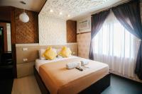 a bedroom with a bed with yellow pillows and a window at Villa Rosita Hotel Naga City by RedDoorz in Naga
