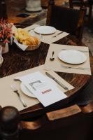 Una mesa de madera con platos blancos y una cesta de pan. en Hotel Mesón de los Cristeros, 