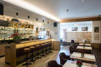 Un restaurante con un bar y algunas mesas y sillas. en Gasthof Hotel Post, en Strass im Zillertal