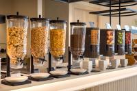 Un mostrador con muchos recipientes de vidrio llenos de cereales. en Hotel RH Arena - Todo Incluido, en Gandía