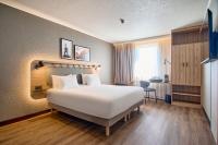 Una habitación de hotel con una gran cama blanca y un escritorio. en CAMPANILE PRIME Krakow Old Town, en Cracovia