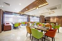 Un restaurante con mesas y sillas en una sala. en Royal Mark Hotel, en Sylhet
