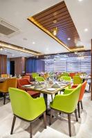 Un comedor con sillas y mesas verdes. en Royal Mark Hotel, en Sylhet