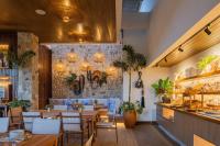 um restaurante com mesas e cadeiras e uma parede de pedra em Saluz Boutique Hotel em Jericoacoara