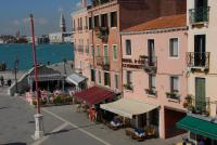 a group of buildings with tables and chairs near the water at Hotel Ca&#39; Formenta in Venice