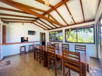 Un comedor con una larga mesa de madera y sillas. en PEKOE VALLEY Huluganga, en Huluganga