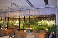 Un restaurante con mesas y sillas y un gran ventanal. en Sun View Hotel, en Addis Ababa